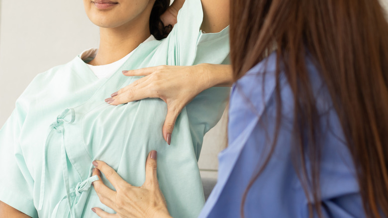 A medical professional examining a patient for breast lumps