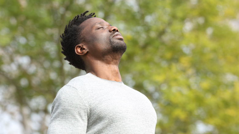 man outside taking a breath 