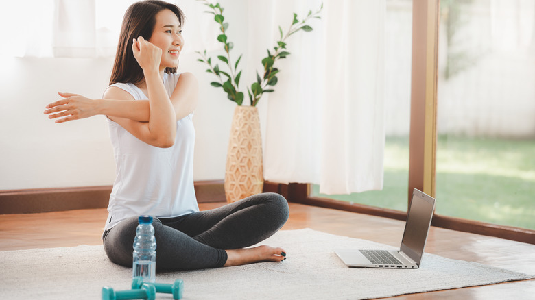 woman stretches inside post workout 