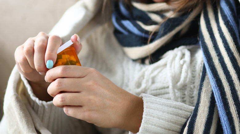 Woman opening pill bottle