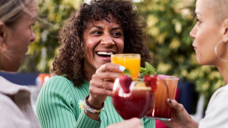 Smiling women drinking cocktails