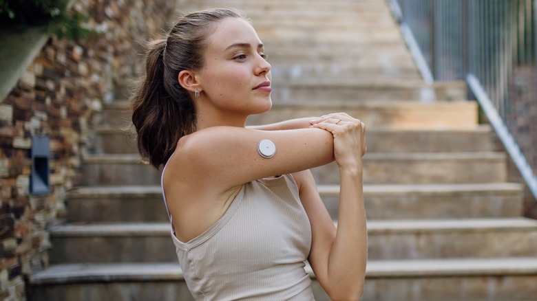 Woman stretching arms outdoors near staircase 