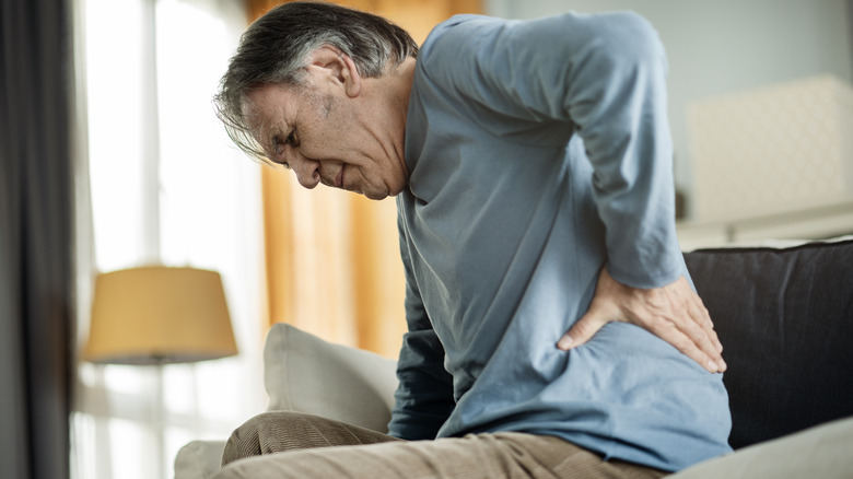 Man touching lower back in pain