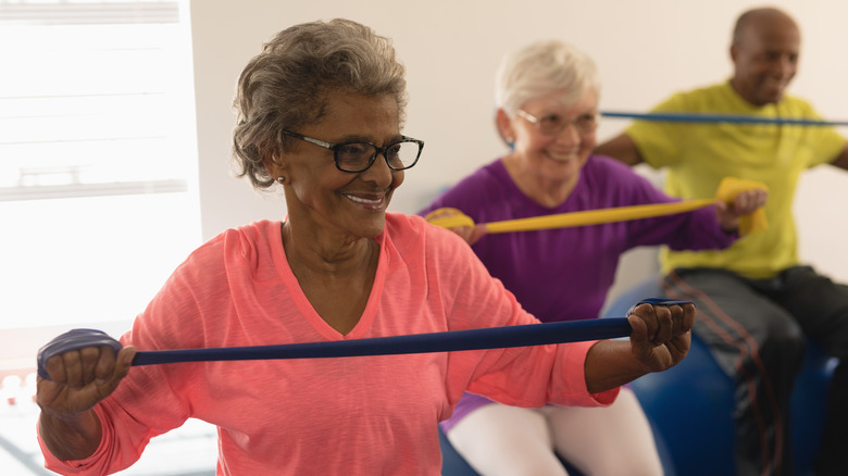 A senior woman pulls an exercise band