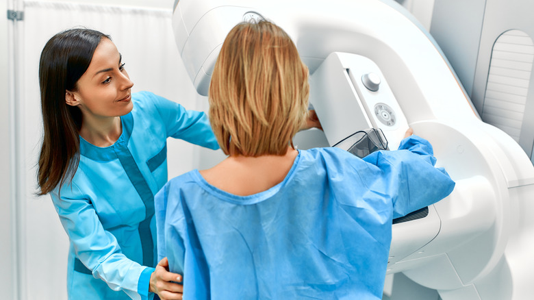 A doctor helps a woman with a mammogram