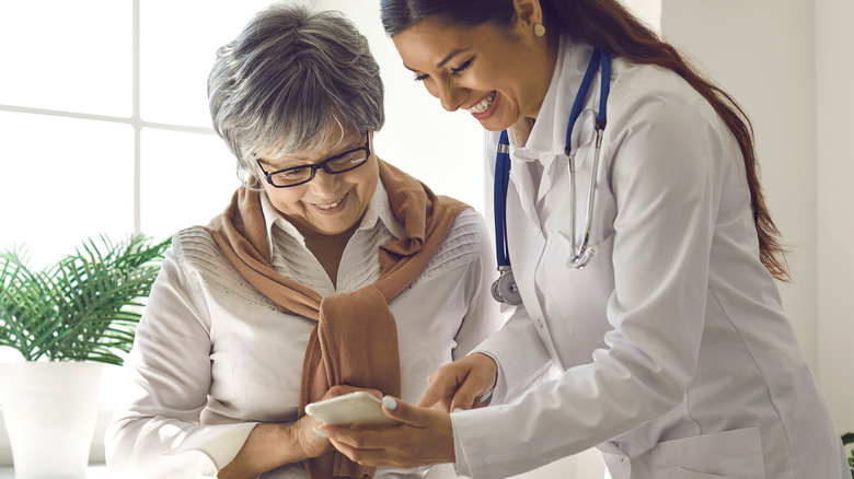 Dark haired doctor with elderly patient