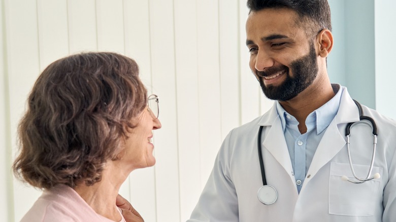 Indian doctor smiling at elderly patient