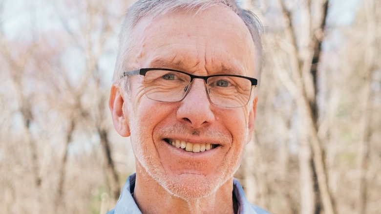 Dr. Thomas Mather smiling in the woods