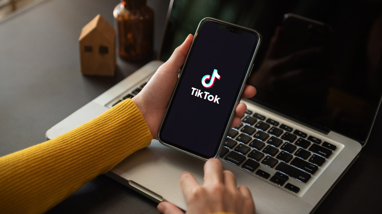 Hands holding smartphone with TikTok app