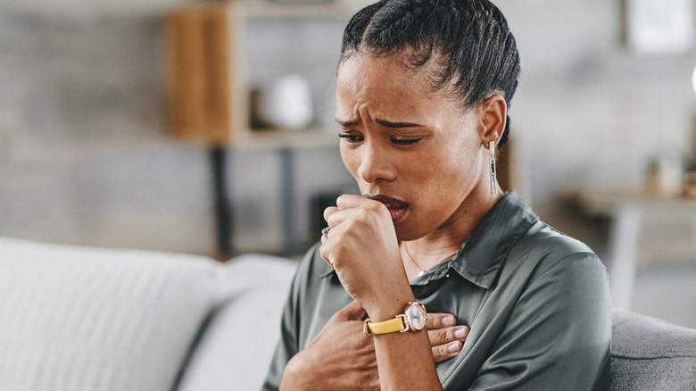 woman sitting at home coughing