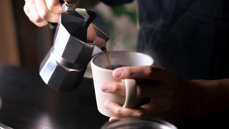 A barista pours a cup of coffee