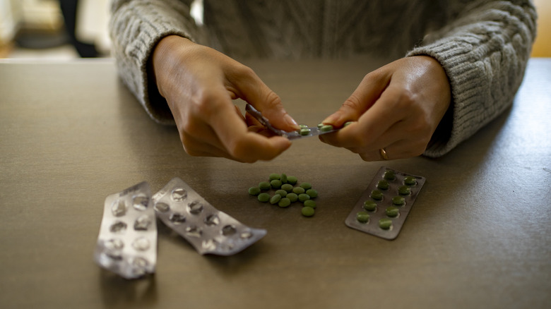 Woman taking pills out of blister packs