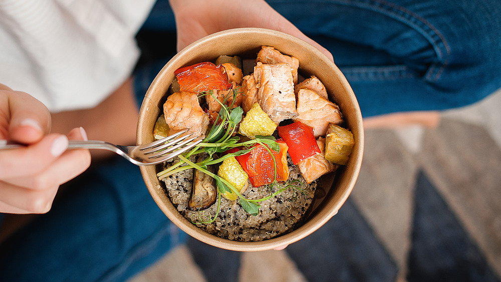 Person sitting on floor holding plate of food