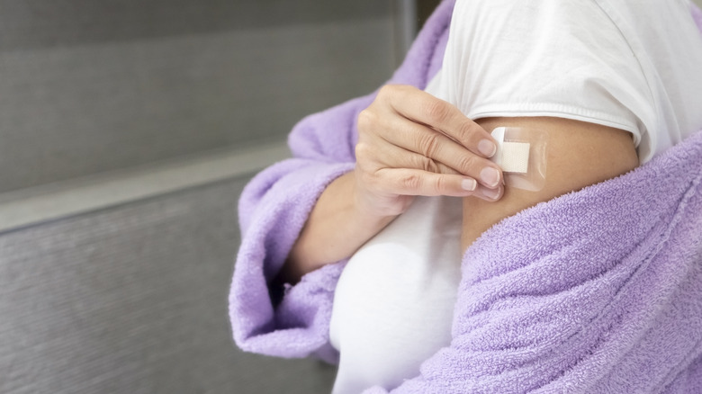 Woman pulling off bandaid