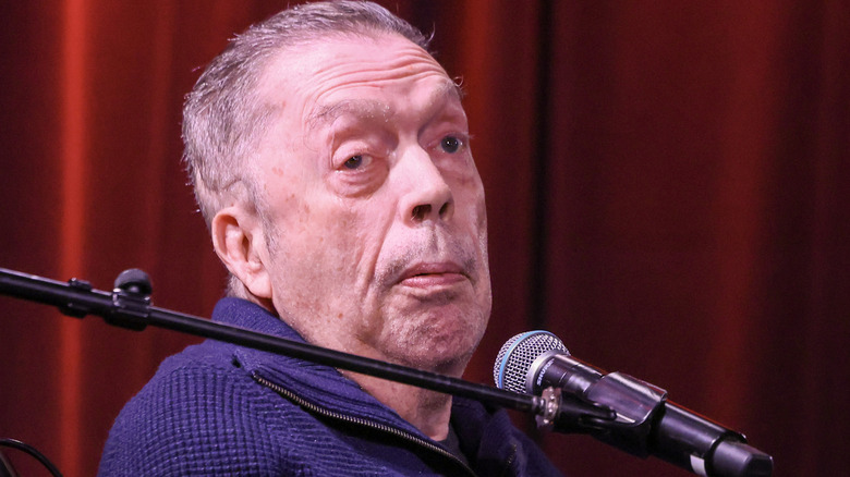 Tim Curry in front of a microphone