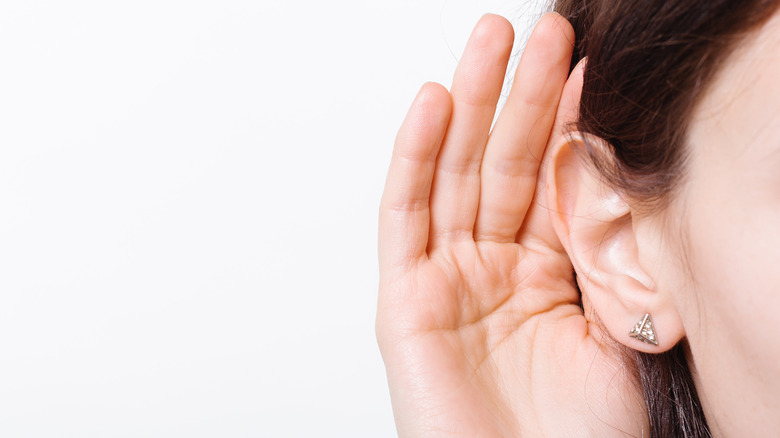 Person cups ear with hand