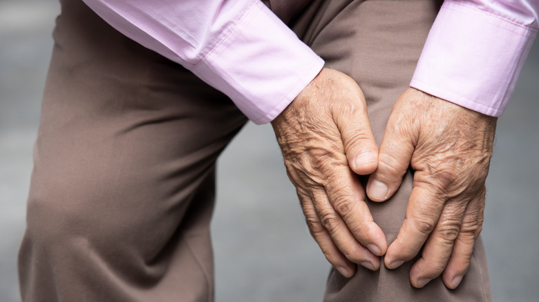 man holds his knee
