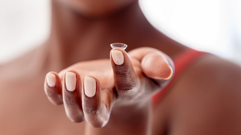 woman with contact lens on hand