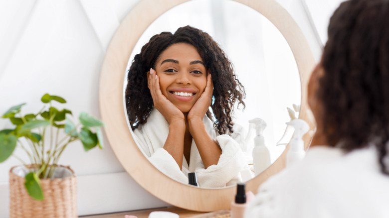 a woman looking at her face complexion 