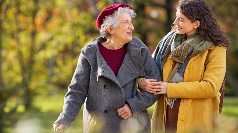 elderly woman walking with caregiver