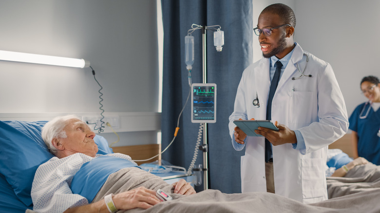 man in hospital bed with doctor