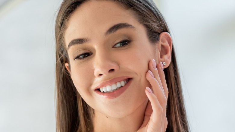 smiling woman touching face