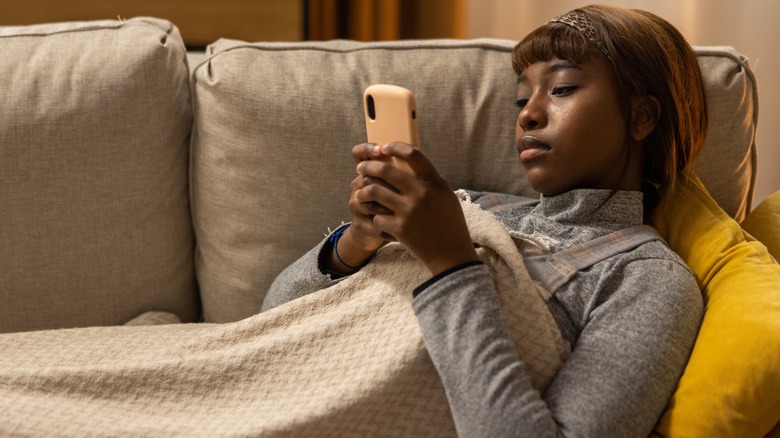 woman on couch with phone