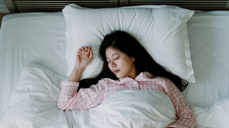 woman sleeping in fluffy white bed