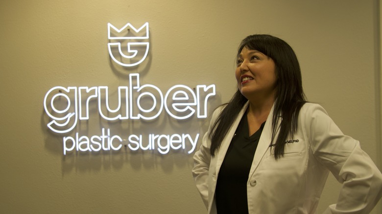Dr. Meegan Gruber posing with her practice's neon sign