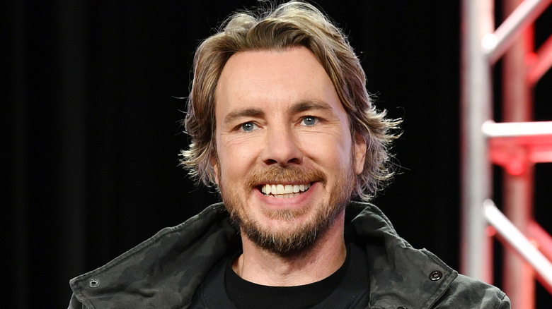 Dax Shepard giving a big smile to an audience at an event