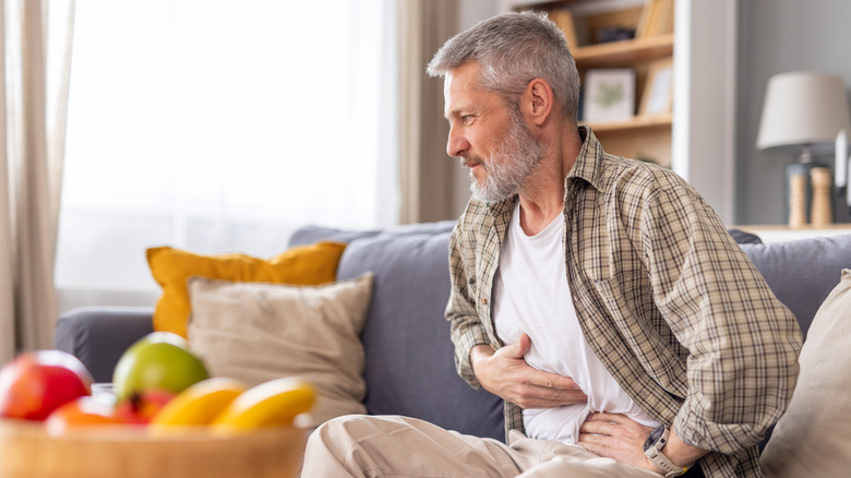 A man with GERD holding his stomach