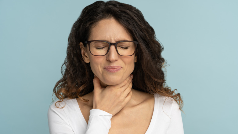 Woman with hand on throat