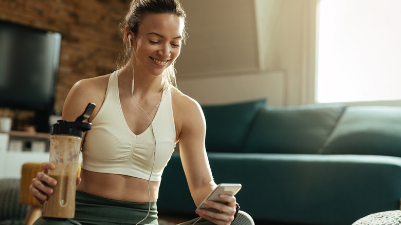 Woman drinking protein shake during exercise