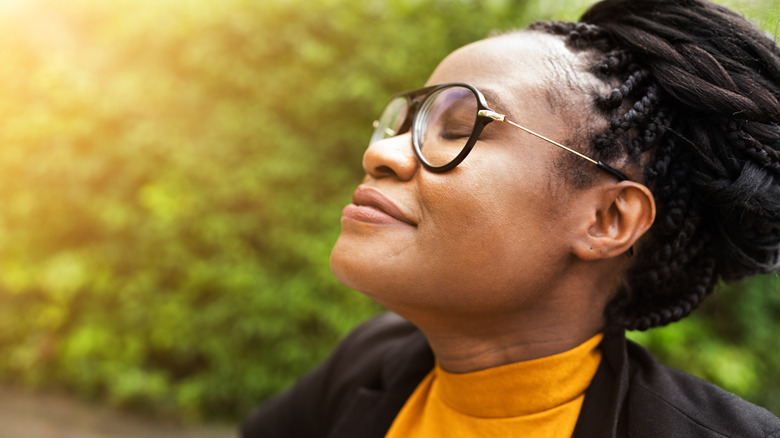 Woman outside smiling with closed eyes 