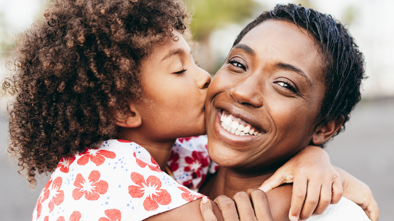 Child kissing mom on the cheek 