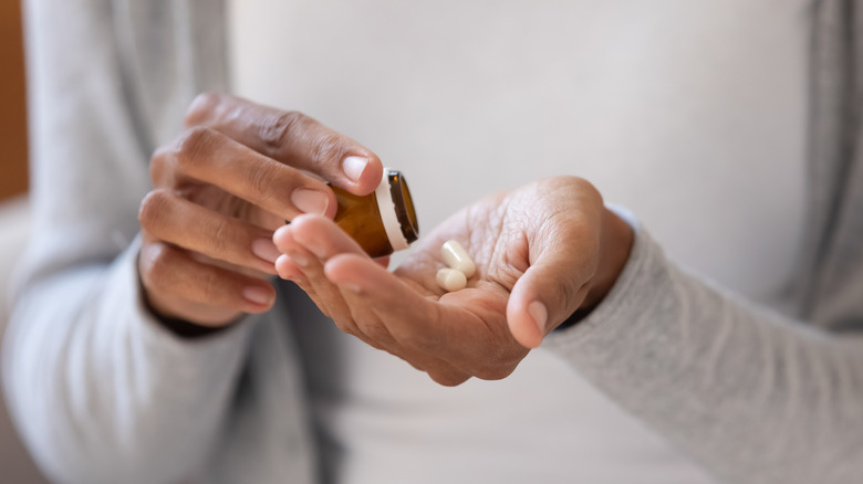 Person pouring pills from bottle