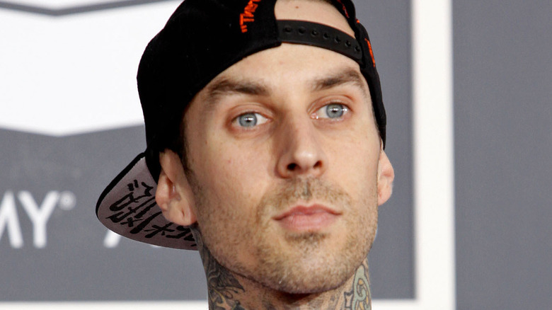 Close up on Travis Barker's face wearing backwards cap