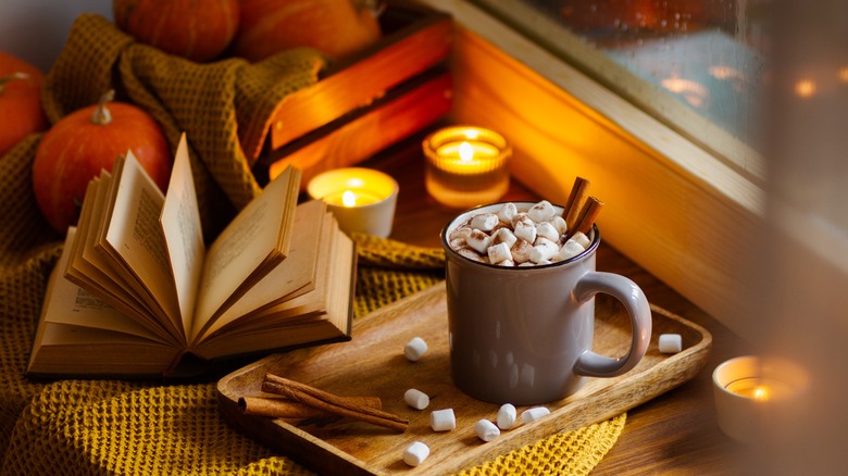 Hot chocolate with book, pumpkins, candles