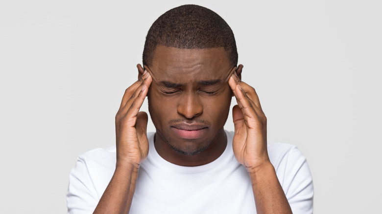 man massaging head