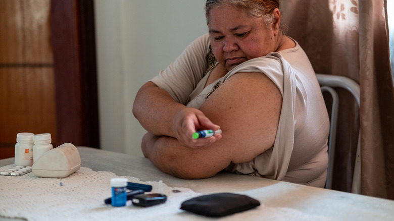 Woman giving herself an injection