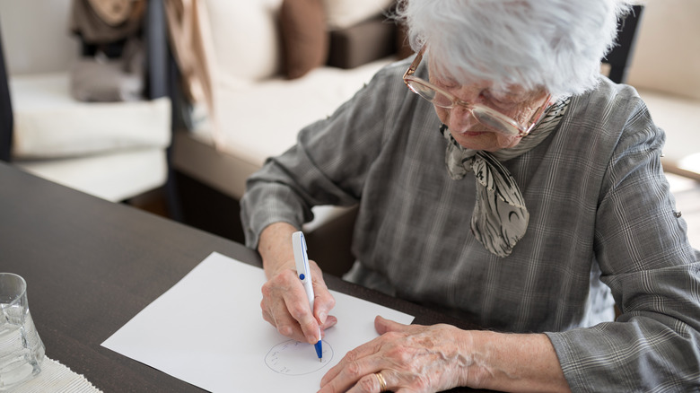 older woman drawing the hands on a clock