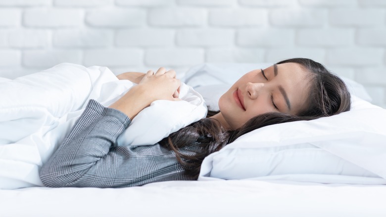 woman sleeping peacefully in a white bedroom
