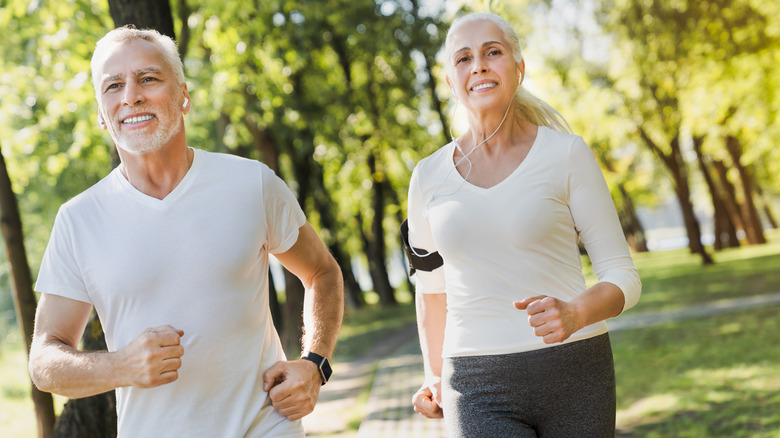 Middle-aged couple jogging outside
