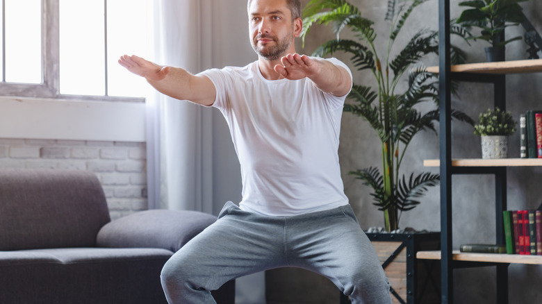 man doing squats at home