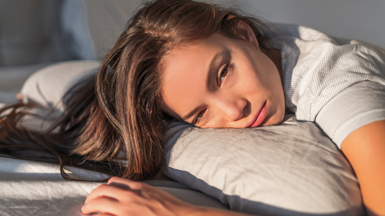 sleepy woman with head on pillow