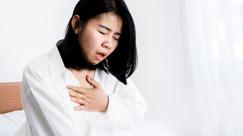 Woman holding chest in pain