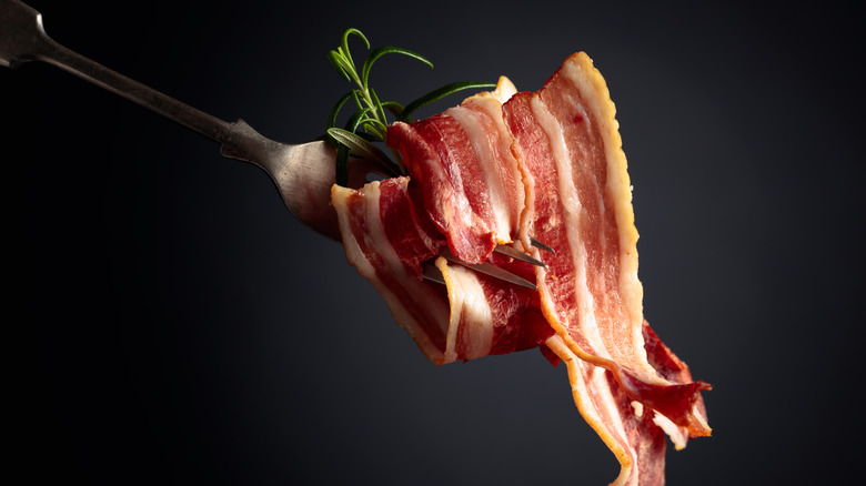 Bacon being eaten with fork