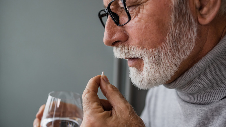older man taking medication