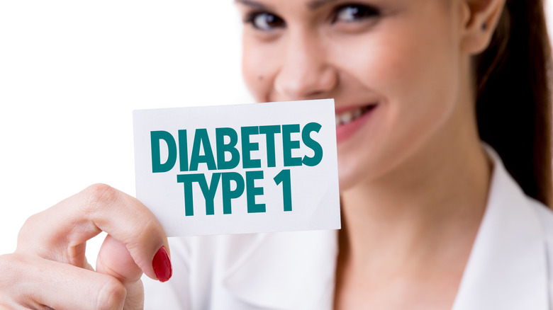 woman holding card that says type 1 diabetes