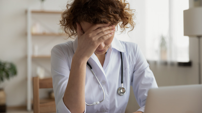 frustrated doctor in front of laptop